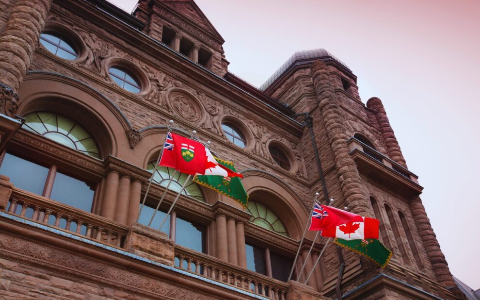 Ontario legislative building with Canadian and Ontario flags waiving out front